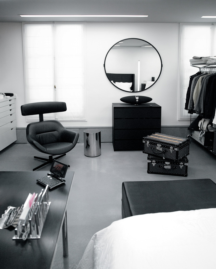 В гардеробной хозяина есть место для рабочего стола, кресла и ноутбука. На полу чемоданы марки Goyard. 