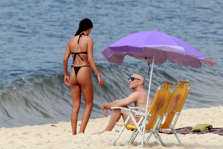Очарованный Венсан Кассель наблюдает, как Тина Кунаки демонстрирует свою потрясающую фигуру в двух купальниках. На пляже ей нет равных