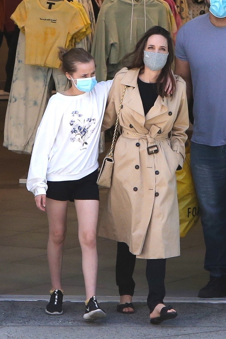 Анджелина Джоли в идеальном тренче и с золотой сумкой в обнимку с дочерью Вивьен