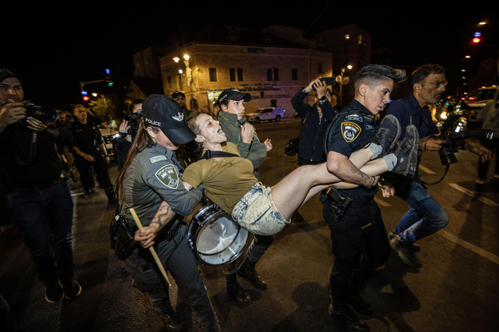 Девушки-полицейские несут барабанщицу, участвующую в массовых протестах против судебной реформы в Иерусалиме