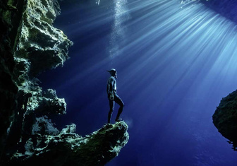 Дайвер позирует в подводной пещере у берегов архипелага Тонга