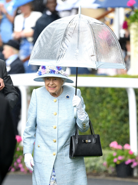 Зонт вместо короны: королева попала под ливень на скачках в Аскоте