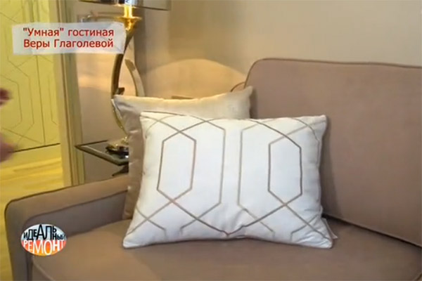 Диван российского производства в английском стиле. Он декорирован подушками, цвет которых сочетается с цветом рисунка на портьерах