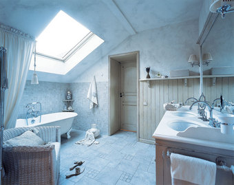 Свет в ванную льется через мансардное окно. Сантехника и смесители от Devon & Devon, подстолье умывальника от Bianchini & Capponi - из салона «Нэксклюзив». Стены вокруг ванны облицованы плиткой, а в менее сырой зоне обшиты деревянными панелями.