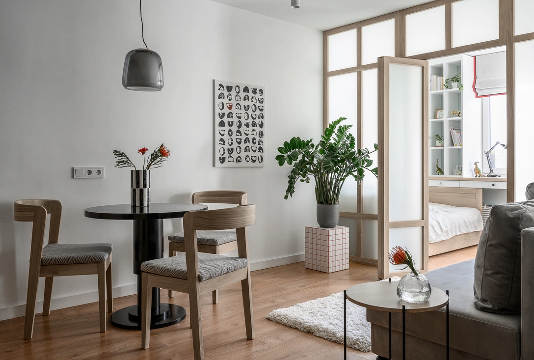 Вид из кухни-гостиной на детскую. Остекленная перегородка, стол и стулья, meblya.zdreva. Картину напротив дивана дизайнер нарисовала специально для этой комнаты. Помимо того, что ее интересно рассматривать (можно увидеть очертания разных фигурок или образов), она имеет и практическое значение — прячет розетки, предусмотренные на случай покупки телевизора. Столик-подставка для большого замеокулькаса также был выполнен руками дизайнера из плитки-мозаики. | Источник: Екатерина Самойлович