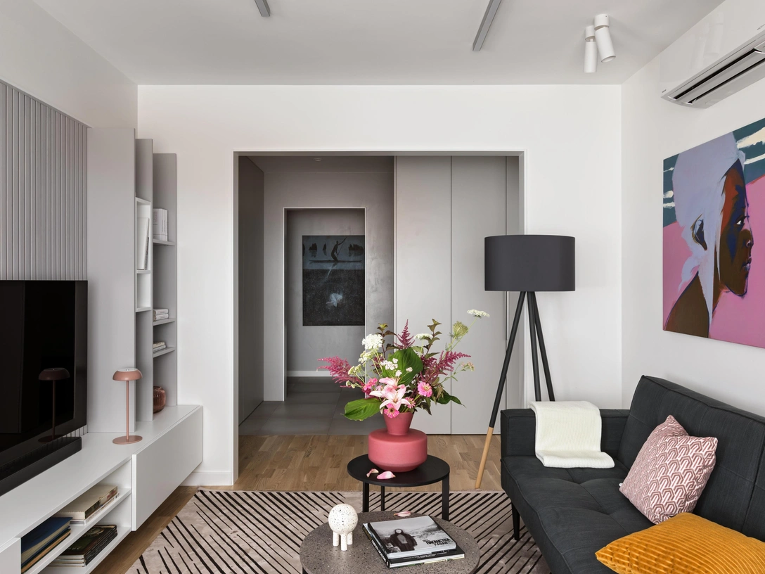 Вид из гостиной на холл. ТВ-стеллаж выполнен на заказ по эскизам дизайнера в столярной мастерской Ambienti. Диванная группа Splitback, Innovation Living. Журнальные столики Joy, Tomasella. Ковер, Pierre Cardin. Настольный светильник Float, Axolight. Торшер Highland, Zuiver. Над диваном работа Кирилла Орсика «Продолжение». В холле работа этого же художника «Граница». Керамика, Ceramic May. Ваза Edg Enzo, De Gasperi. Паркетная доска, Boen. Флористика Ольги Колос. | Источник: Егор Пясковский