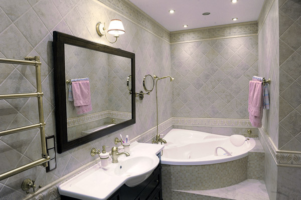 Светлая плитка в ванной увеличивает пространство помещения, а выполненная из меди фурнитура придает комнате дух классики
