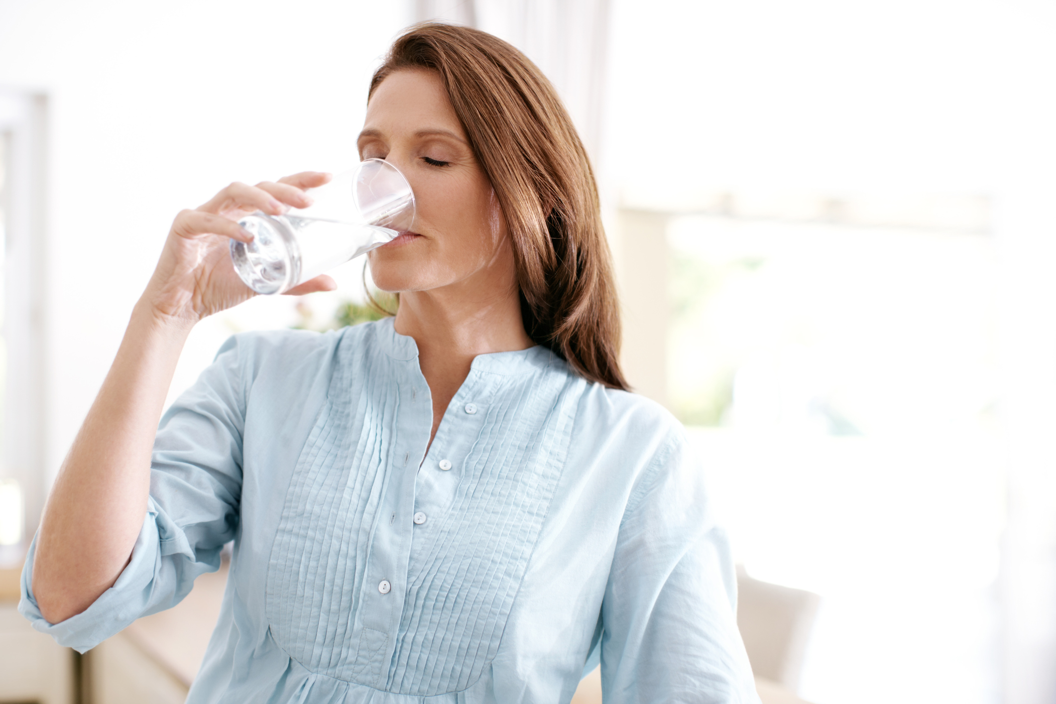 Пить воду стоя или сидя. Девушка пьет воду. Женщина пьет воду из стакана. Девушка пьёт воду перед сном. Женщина жадно пьёт воду.