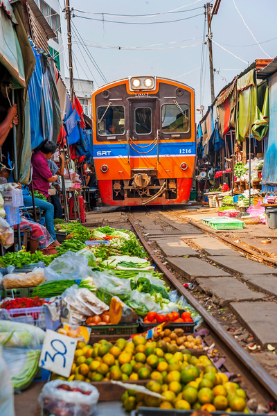 Тайские продавцы убирают товары с пути поезда