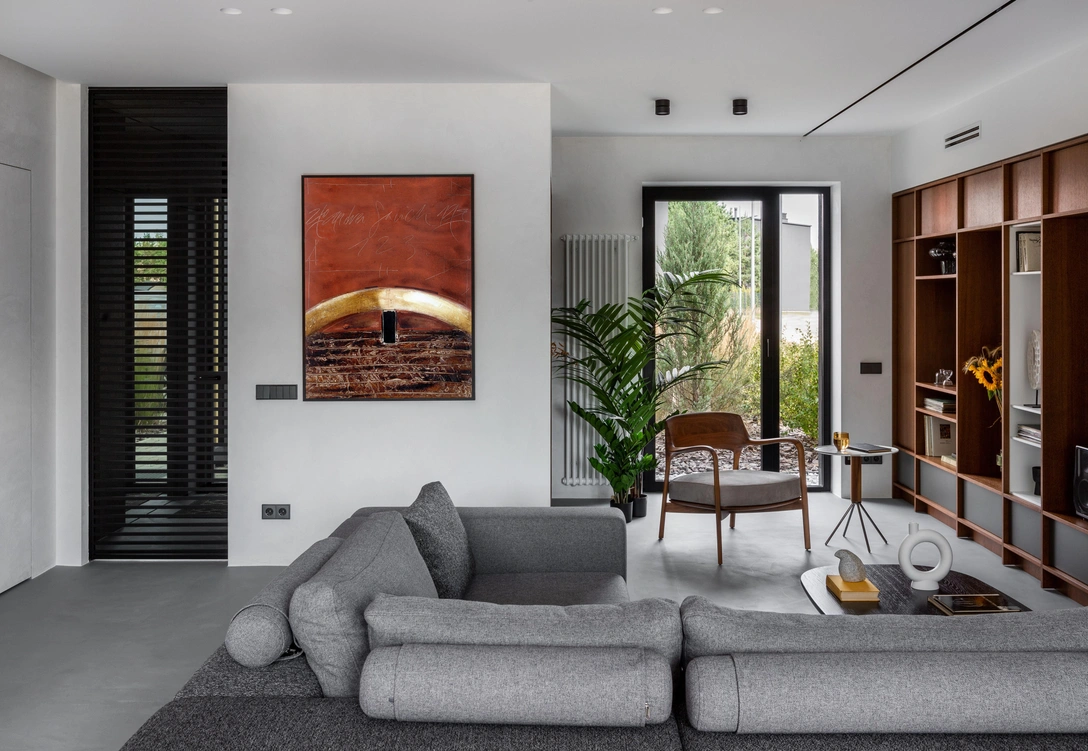 Недалеко от входа располагается зона отдыха и чтения книг. Кресло и столик, Porada. Корпусная мебель сделана на заказ по эскизам дизайнера в компании Domani. Скульптуры на ножках, Лиза Пулко. Ваза, Goebel. Живопись художника Андрея Савича. | Источник: Сергей Пилипович