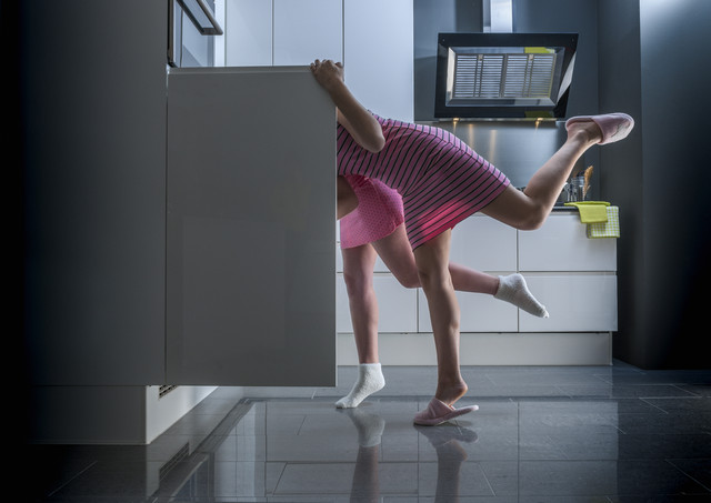Девушка заглядывает в холодильник