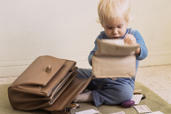 Ребенок рассматривает содержимое маминой сумки