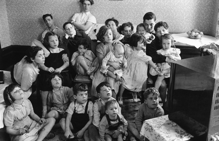 Чарльз и Элизабет Хадсон смотрят телевизор со своими двадцатью детьми и шестью внуками в восьмикомнатном викторианском доме в Лондоне. 24 сентября 1953 года.