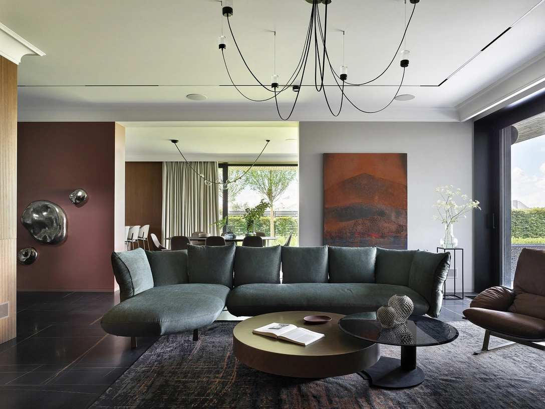 Общая зона на первом этаже, фрагмент. Диван и кресло, Arketipo. Журнальный стол, Cattelan. Стеновые панели, Domani. Ковры, Carpet Edition. Напольная плитка, FMG. | Источник: Сергей Ананьев. Стиль: Юлия Мамедова