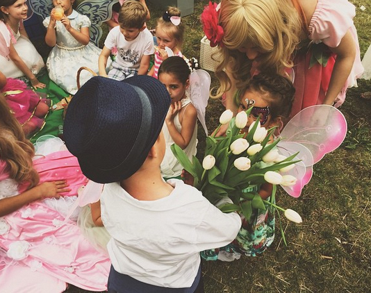 Сын Водонаевой с букетом белых тюльпанов на детском празднике