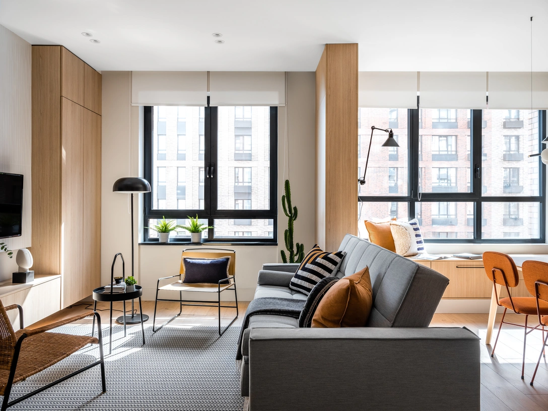 Вид на гостиную-столовую. Корпусная мебель и панели выполнены на заказ. Диван, плетеное кресло, столик с ручкой, торшер, ковер, все — ИКЕА. Каркасное кресло и подушки декоративные, H&M Home. | Источник: Евгений Кулибаба