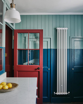 Когда дверь в кухню открыта, она служит ярким брусничным акцентом на фоне синих стен.