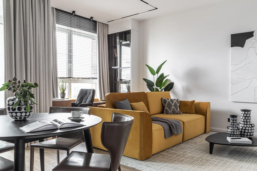 Зона гостиной. Диван, мягкие подушки на подоконнике «Лавсит». Корпусная мебель (ТВ-зона, рабочий стол, стеллажи, экран под мягким подоконником) «Красивые кухни». Рабочее кресло Tetchair. Журнальный стол SK Design. Ковер — Kover.ru. Шторы и жалюзи — Салон штор «Душистый горошек». | Источник: Женя Муравьева. Стиль: Екатерина Шаповалова