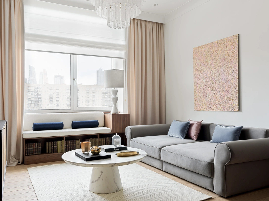 Гостиная. Серый диван выполнен на на заказ. «Диван в окне» выполнен по эскизам дизайнера. Журнальный стол, Pols Potten. На стенах — краска Loft White, Little Greene. Картина работы Framavi. Ковер, «Культура Ковров». | Источник: Сергей Красюк стиль: Екатерина Наумова