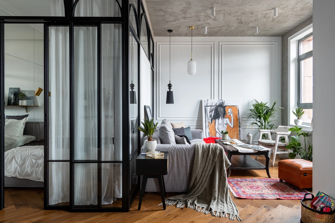 Стеклянная раздвижная перегородка разделяет гостиную и спальню. Два больших «нью-йоркских» окна, из которых открывается красивый вид на Москву-сити, архитектор решил не закрывать шторами и превратить в арт-объект. | Источник: Евгений Гнесин. Стиль: Ирина Бебешина