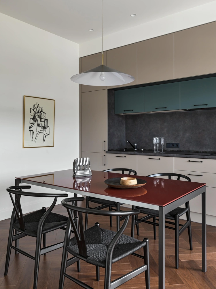 Кухня. На стене — литография Осипа Цадкина. Обеденный стол, Sedit. Стулья, Carl Hansen & Son. Кухня беларусcкого производителя выполнена на заказ, «ТерраМебель». Паркет, Par-ky. Светильник, Miloox. На столе — скульптура Елены Чепелевой. Деревянные тарелки, Zaretsky Woodwork. | Источник: Егор Пясковский Стиль: Юлия Мамедова