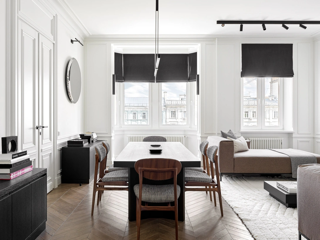 Вид на гостиную из холла. Стол, шпон дуба тонированный, изготовлен на заказ по эскизам дизайнера. Люстра Vertigo, Michael Anastassiades. На столе: блюдо из цельного дуба, Wood Zen Art. Стулья Agio, Dale Italia, обиты тканью Dedar. Шторы, Houles. | Источник: Сергей Красюк. Стиль: Наталья Онуфрейчук