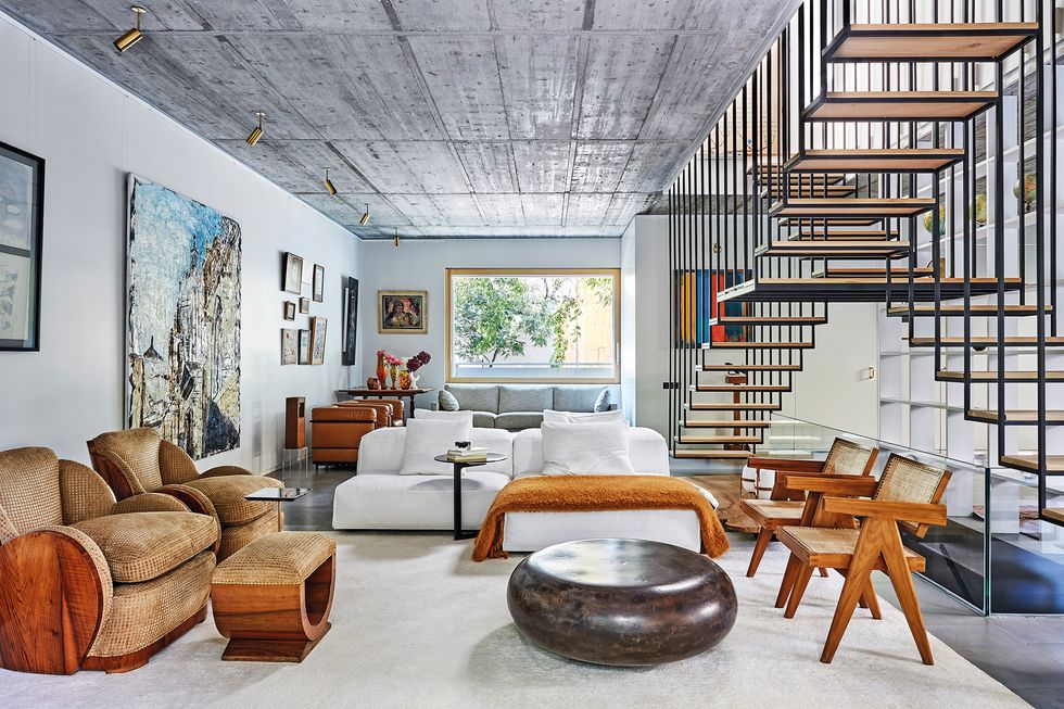 Лаундж-зона в гостиной. Журнальный столик из мрамора Baba, Poliform. В центре кресло Coffee Bean, Mccollin Bryan. Справа — два винтажных кресла из Чандигарха, дизайн Пьера Жаннере. Латунные светильники на потолке, подсвечивающие картины на стене, спроектированы студией BETA.Ø. | Источник: Пабло Сарабиа